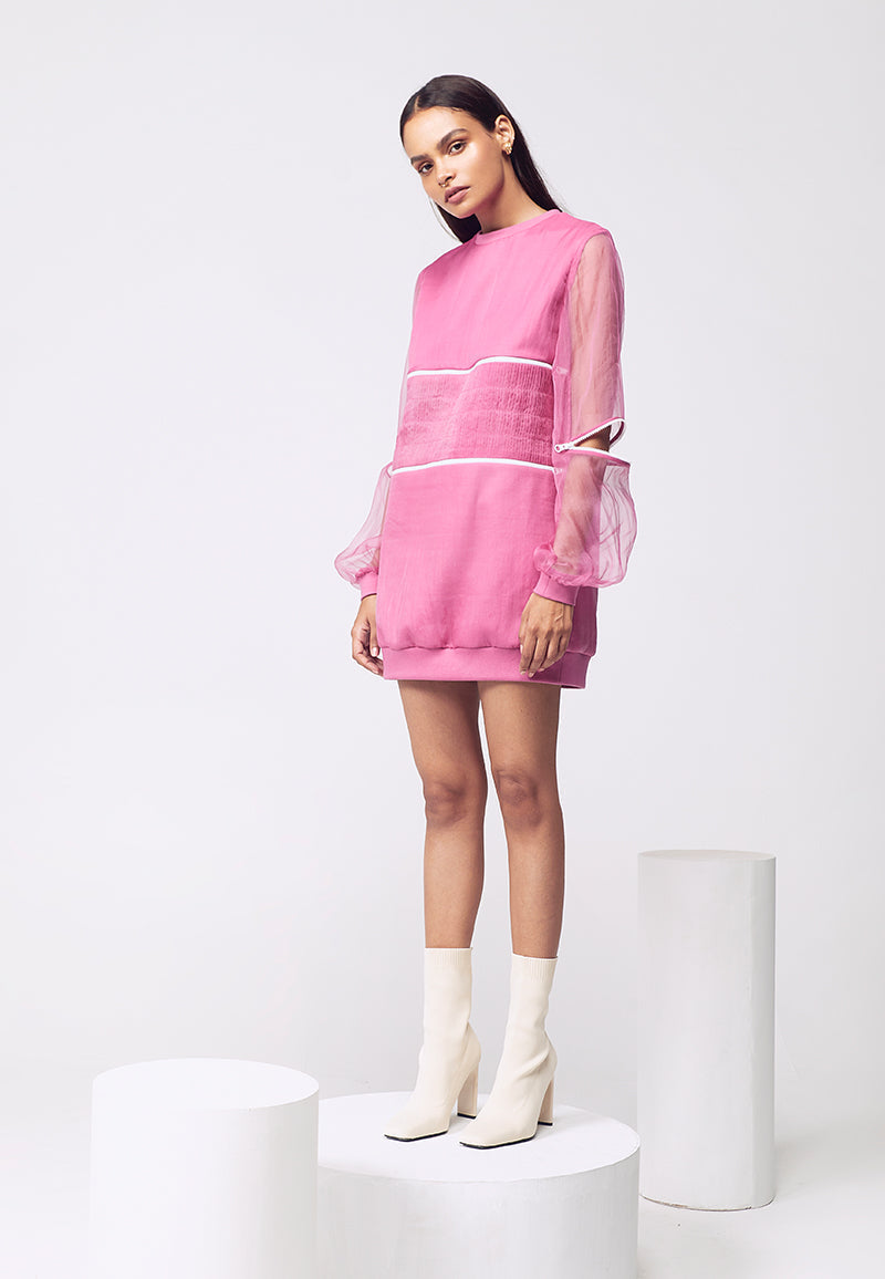 Comfort meets elegance in this baggy sweatshirt mini dress. Handcrafted in cotton knit this loose-fit ensemble with organza pleating detail is multifuntional. The white zipper details add to the look and make it versatile. Wear it as crop top, mini dress, or sweatshirt for summers, spring, or fall. Pair it with sneakers for brunch for a streetwear look or with booties for a casual outing with friends or dinners.