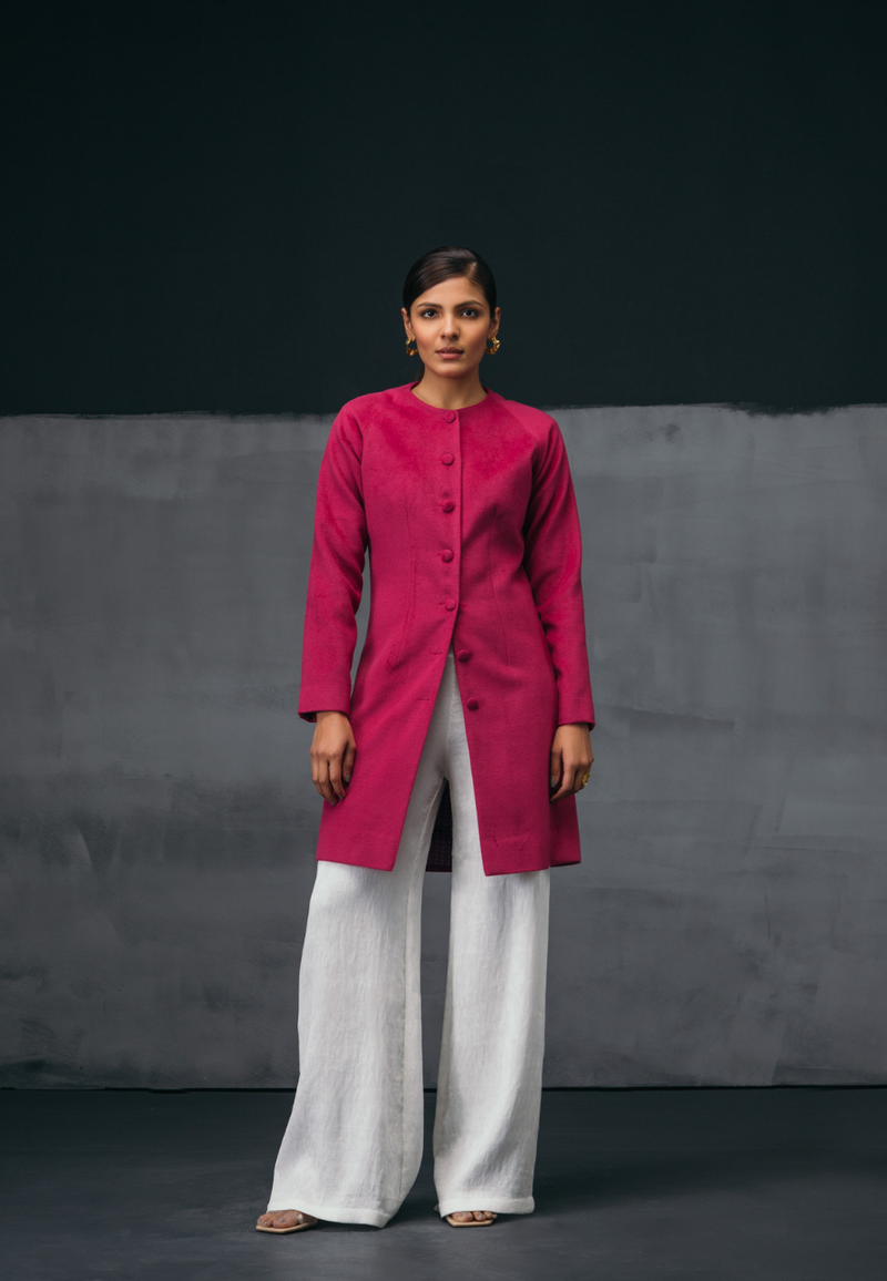 Mannat Gupta's collection of women's jackets and coats. This collarless pink wool coat features wool buttons as closures on the front. It has long sleeves and is cut right on the knee. It the perfect coat for breezy winters. You can wear it to work or for your next dinner plan with girlfriends. Pair it with straight pants and a cropped sweater along with pumps to complete the look.