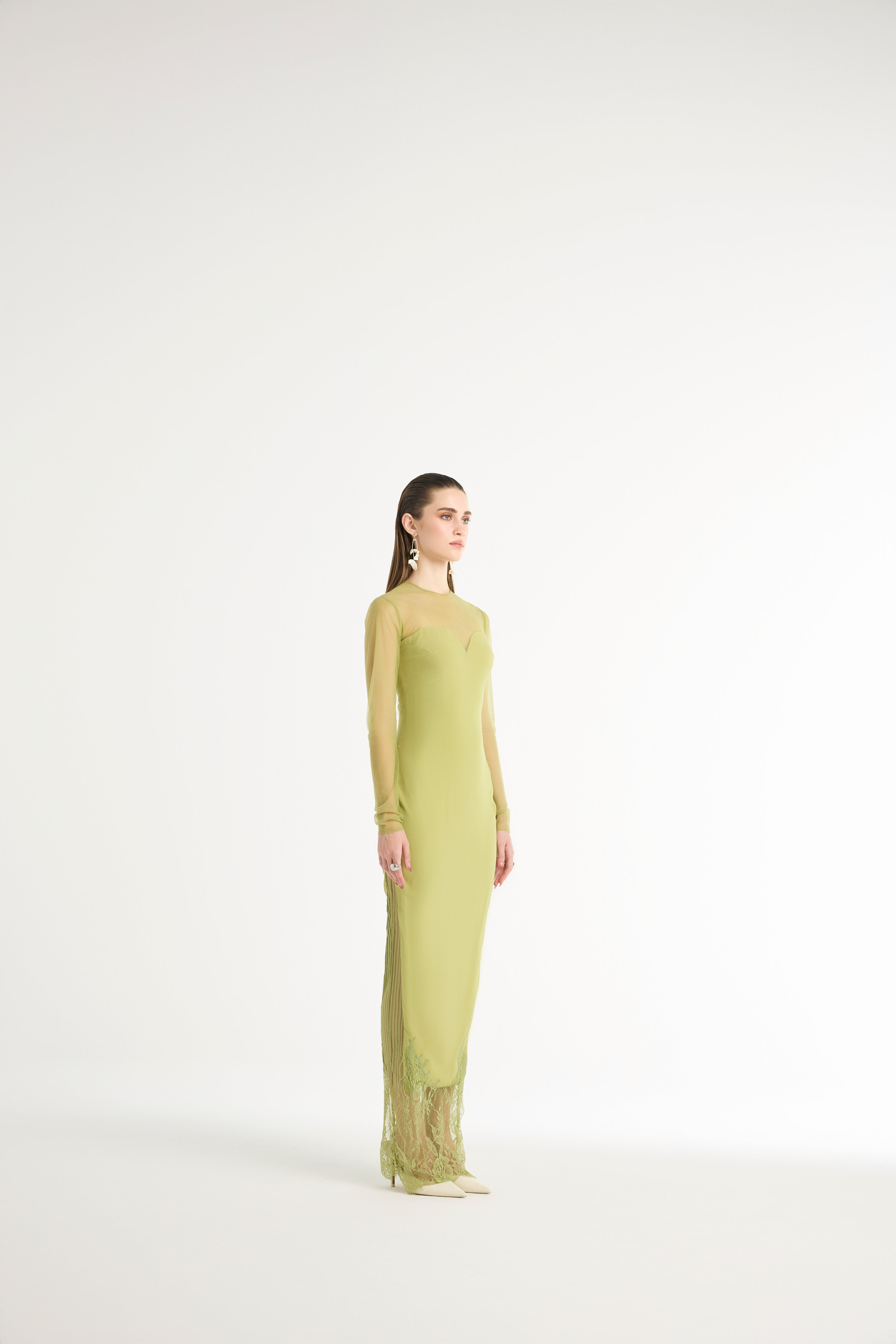 Woman wearing a long green dress on a white background