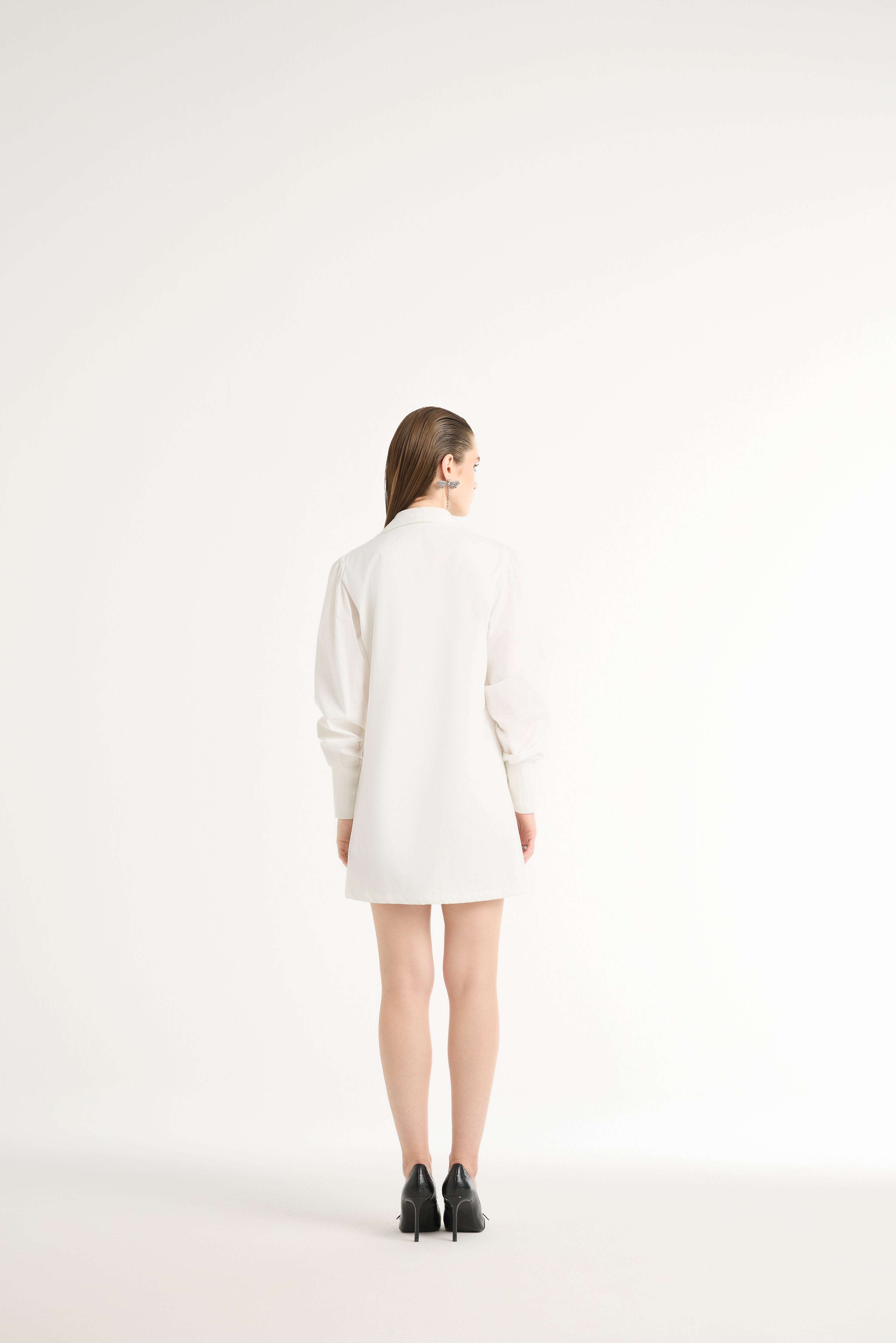 Person wearing a white coat on a plain background