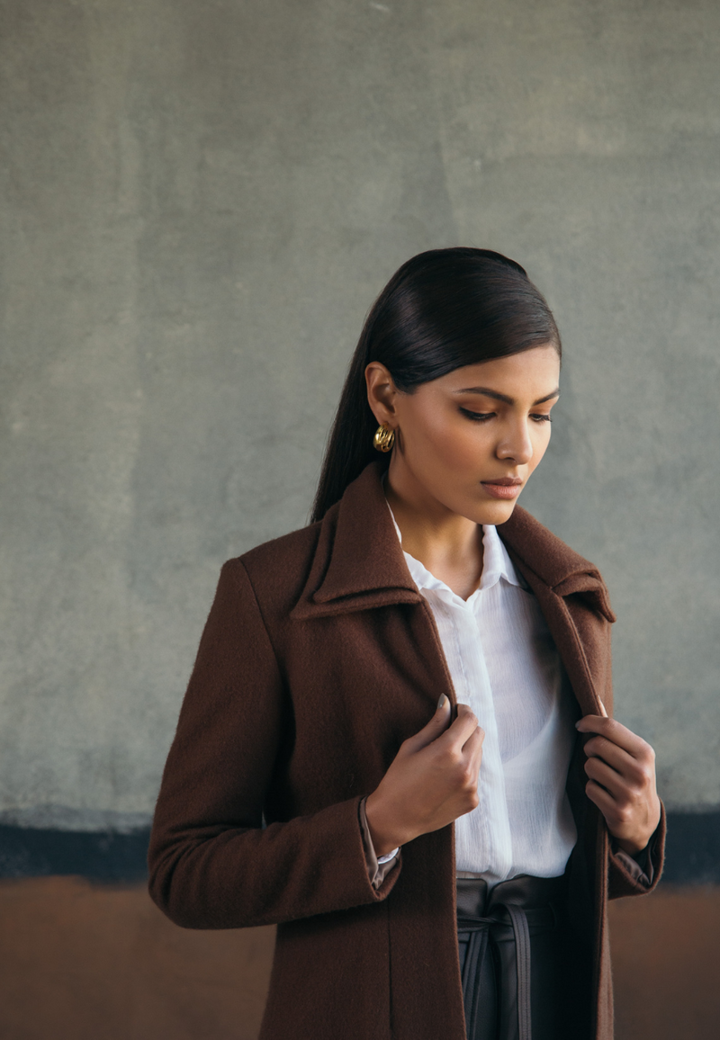 This woman’s brown double collared wool coat is chic and versatile. Crafted from plush wool, the wool jacket features a double collar with princess lines in the front for a more fitted look. This knee-length coat is a definite style statement for the winters. The easy and comfortable fit on the front make it perfect and versatile for layering over anything.