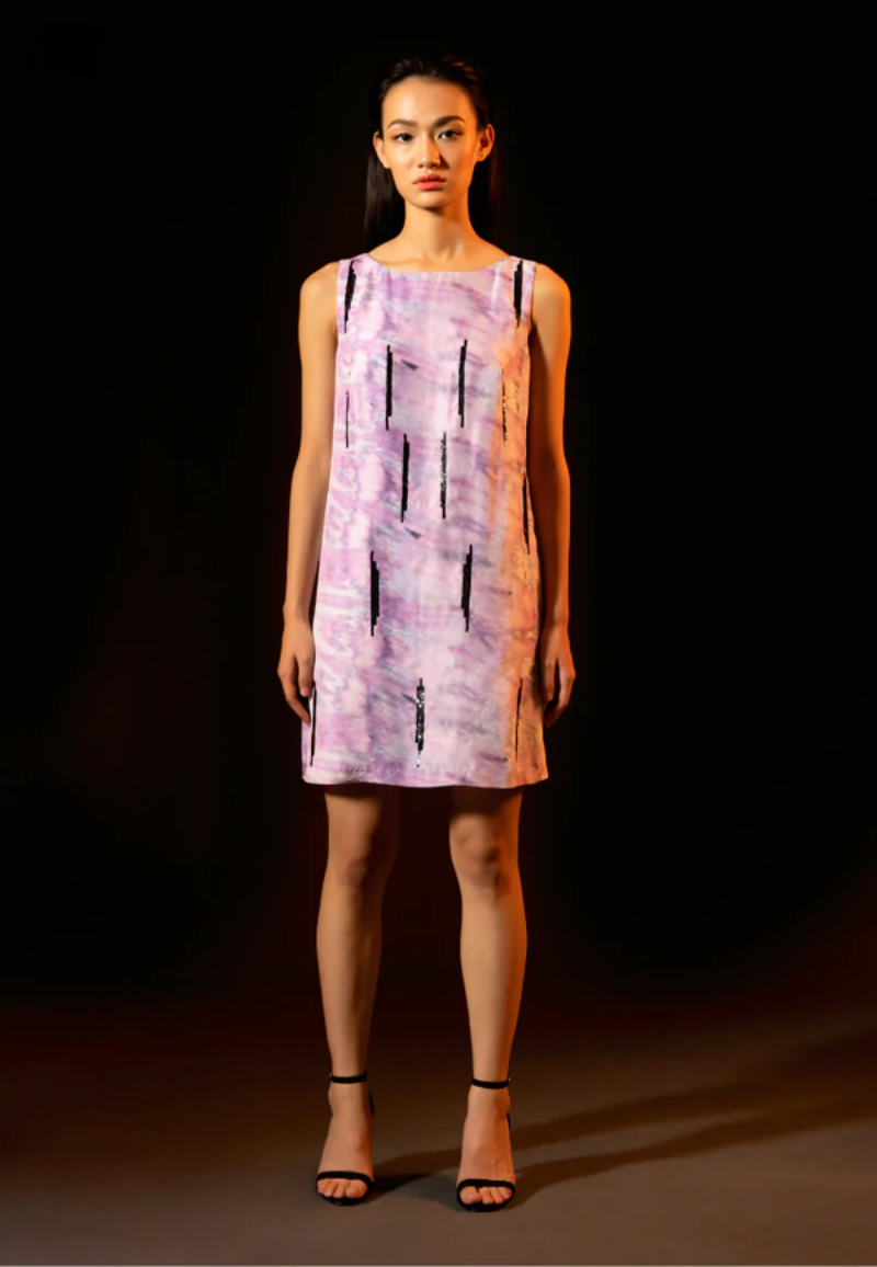 Versatile and minimal dress collection from Mannat Gupta which every woman will love to have. You can style in this beautiful embellished short A-line dress which is made of luxe silk and printed with a purple tie-dye pattern. This flared mini dress is crafted with black sequins. Pair this sleeveless mini dress with heeled sandals and minimal jewelry for your next night out.