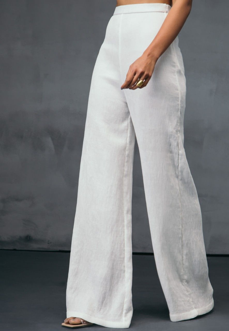 These high-waisted flared pants in white are must have for all the seasons. Crafted from stretchable pre-pleated jersey knit, this style sits high on the waist. Style yours with a crisp shirt or a crop top for the summers or spring. Or style the pants with your favorite coat or jacket for the fall or winters.