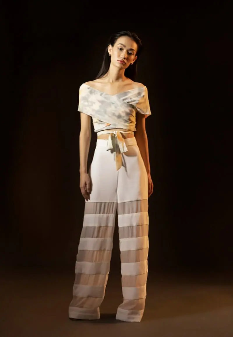 Women’s high-waisted straight pants panelled with silk crepe and chiffon in white; the perfect pair of pants to deal with the summer’s heat. Complete the look with a printed crop top and heeled sandals.