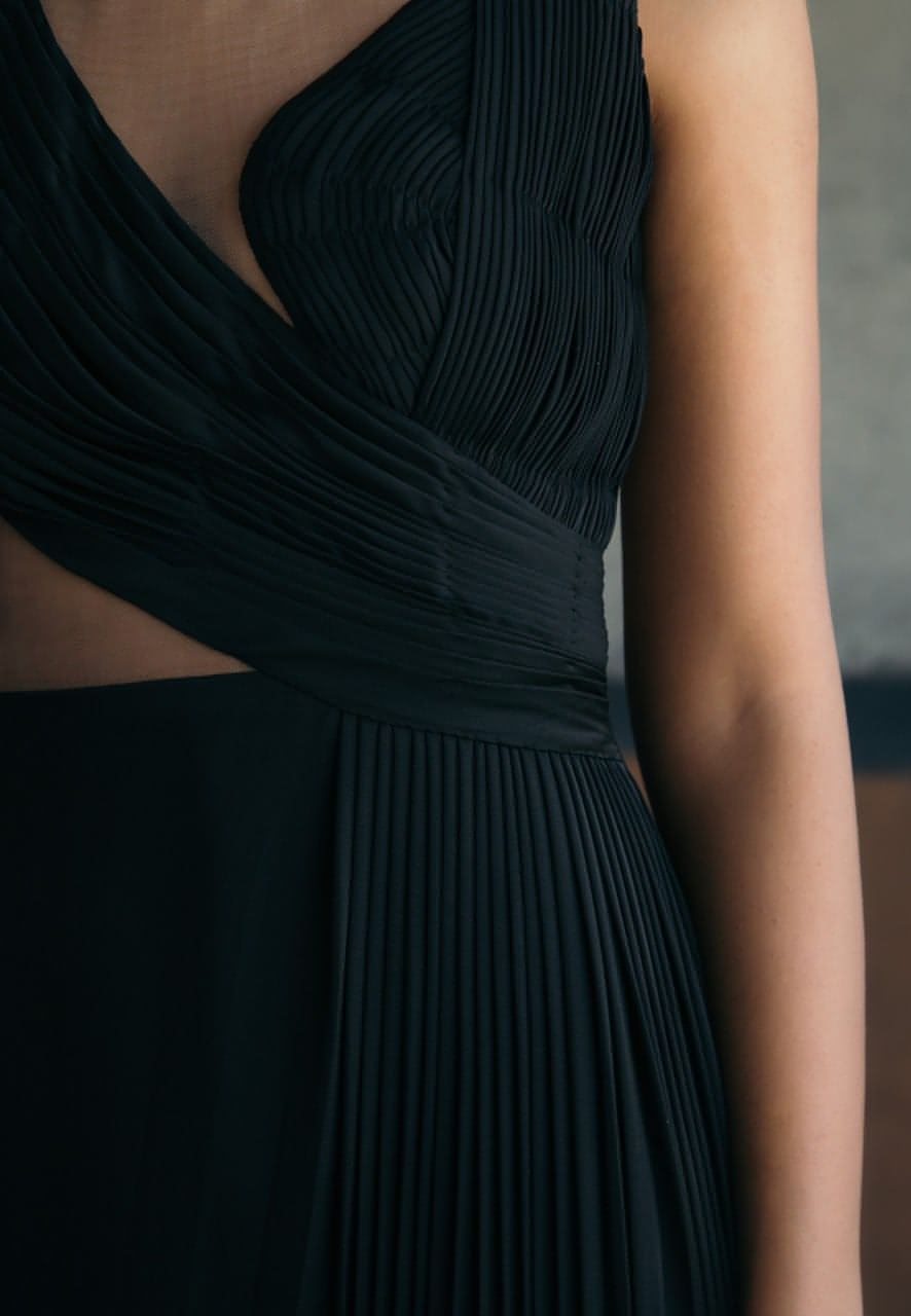 Woman's maxi dress crafted from black satin crepe fabric is a must-have for the evenings. This sleeveless floor-length gown features delicately draped ruching and pleating details with a sheer back made out of net. Style it with minimal gold jewelry and heeled sandals for an elevated look.