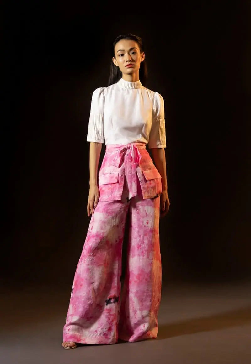 This beautiful tie-dyed high-waisted pants made from lustrous silk is sure to grab attention. Wear it in the summers, spring or fall for its tonal pink and white hues. Skirt and flap pockets in the front is highlight of the ensemble. These pants are perfect for all the seasons and can be paired and layered with almost anything.