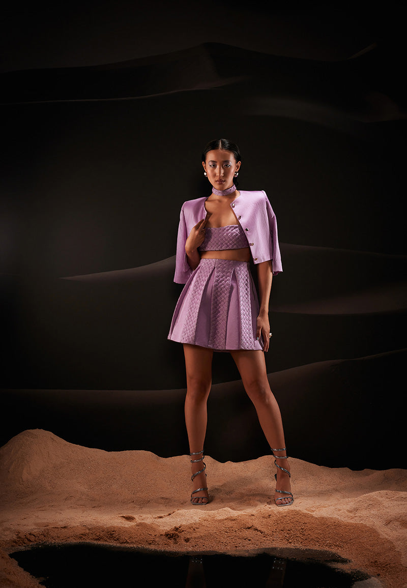 This beautifully handcrafted 3-piece co-ord set is designed to create an impact wherever you go. It features a weaved bandeau top, high-waisted box pleated skirt accompanied with a short jacket with a round neckline in pastel violet offering a flawless and tempting look. The ensemble is cut from hand-dyed linen satin fabric giving it a luxurious and comfortable look. Pair yours with strappy sandals and gold jewellery to amplify the look.